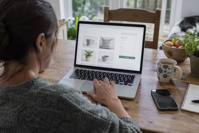 A shopper reviewing an online order on a laptop at home